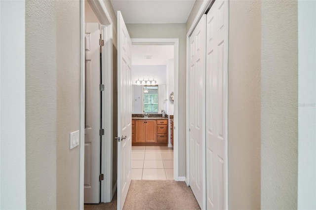 corridor with sink and light tile patterned flooring