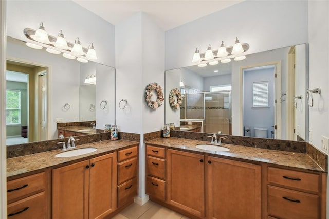 bathroom with vanity, toilet, walk in shower, and tile patterned flooring