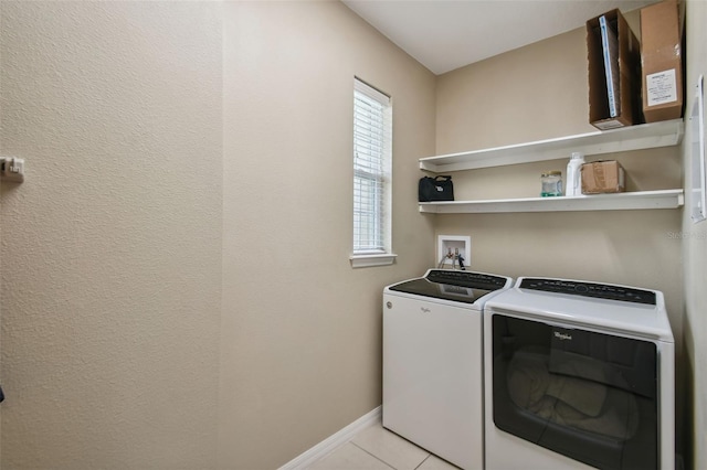 clothes washing area with a wealth of natural light, independent washer and dryer, and light tile patterned flooring