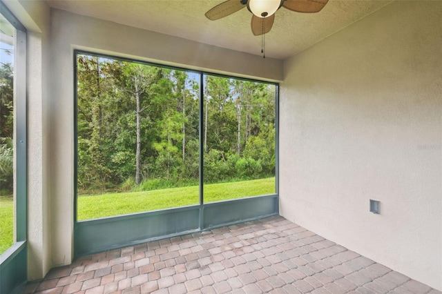 unfurnished sunroom featuring ceiling fan