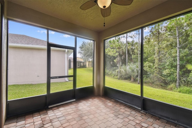 unfurnished sunroom with ceiling fan