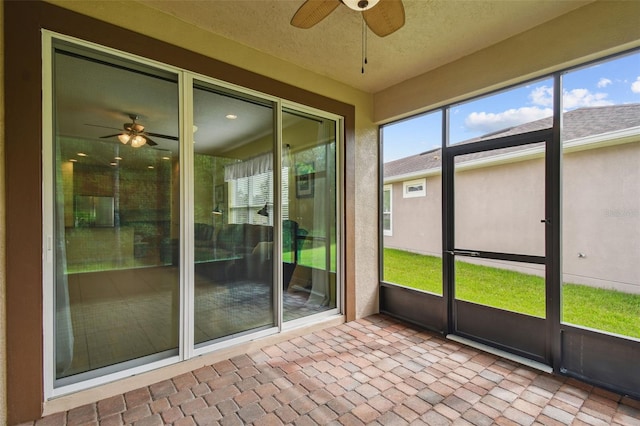 unfurnished sunroom with ceiling fan