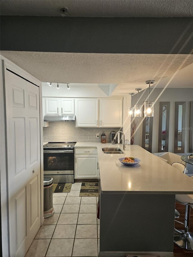 kitchen featuring hanging light fixtures, light tile patterned floors, sink, white cabinetry, and electric stove