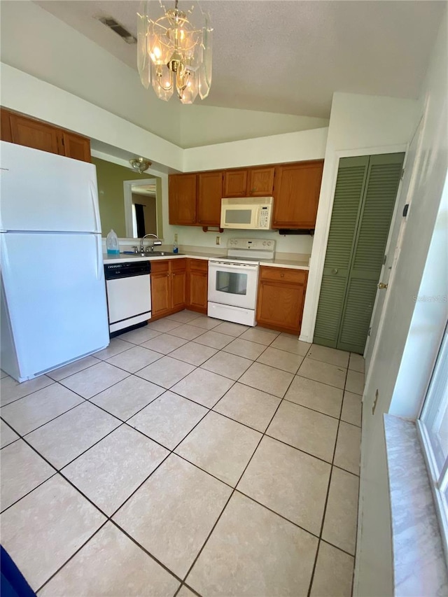 kitchen featuring hanging light fixtures, lofted ceiling, white appliances, and light tile patterned floors