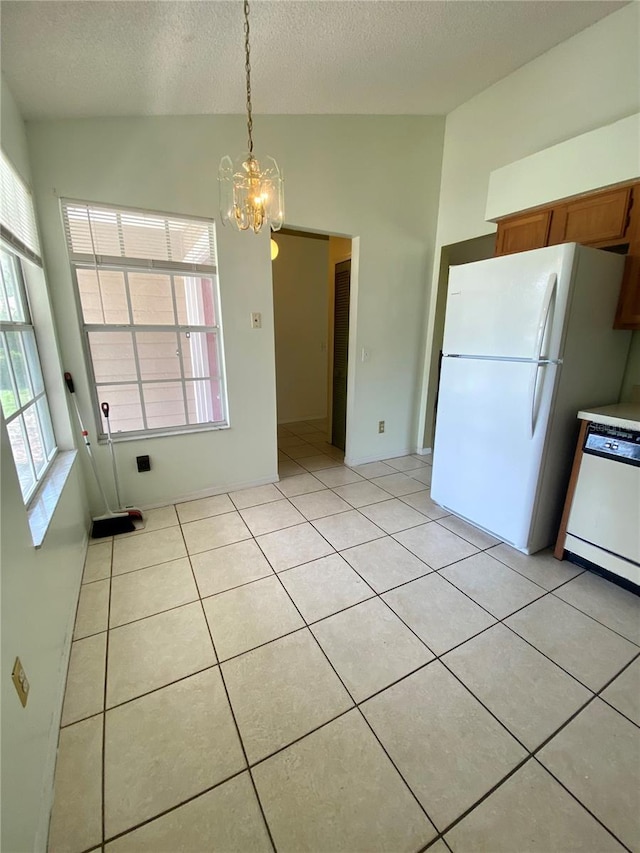 unfurnished dining area featuring a textured ceiling, vaulted ceiling, an inviting chandelier, and light tile patterned floors