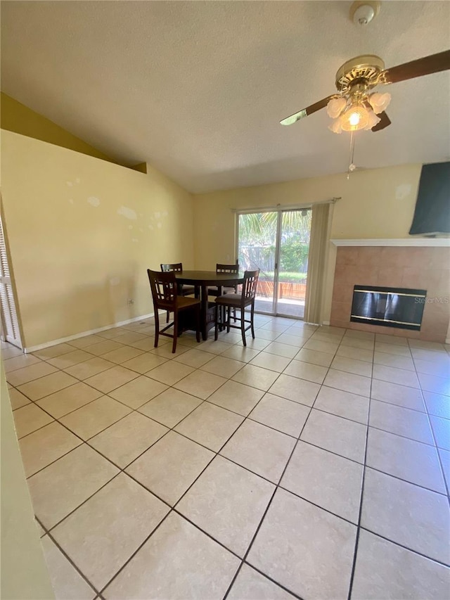 dining space featuring ceiling fan, light tile patterned flooring, a textured ceiling, and lofted ceiling