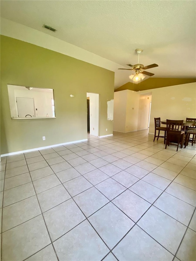 interior space with ceiling fan, a textured ceiling, and lofted ceiling