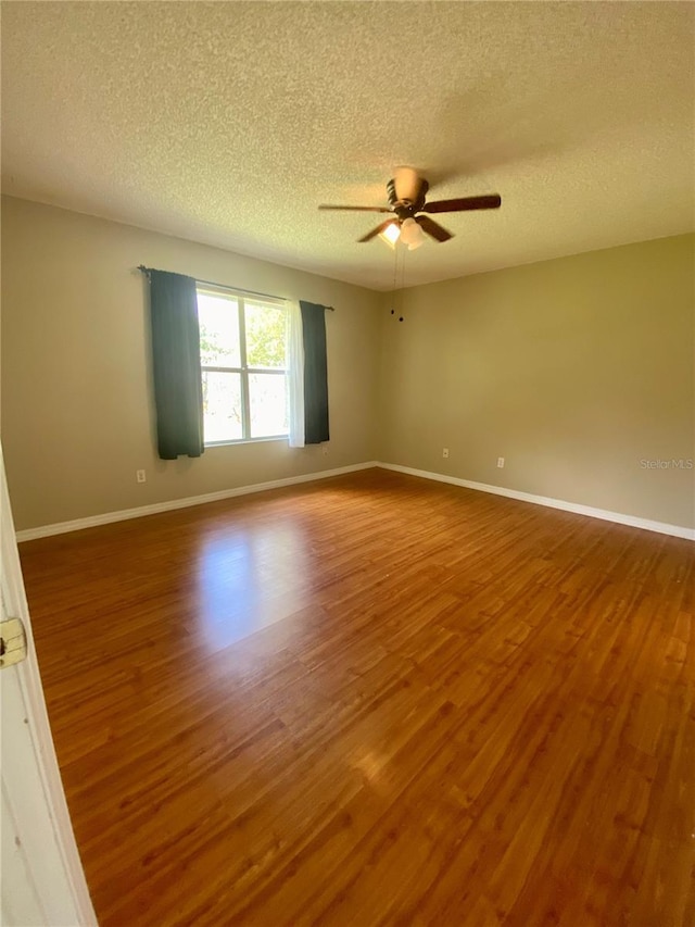 spare room featuring hardwood / wood-style flooring, a textured ceiling, and ceiling fan