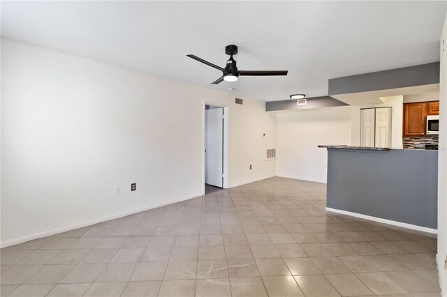 unfurnished room featuring ceiling fan and light tile patterned flooring