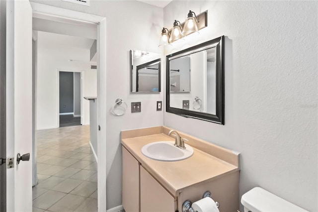 bathroom featuring tile patterned flooring, vanity, and toilet