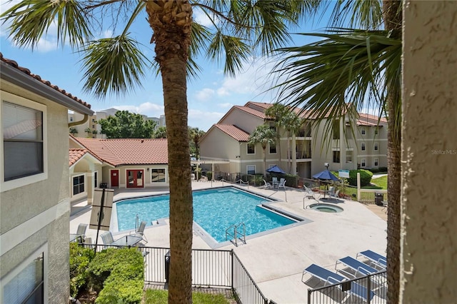 view of swimming pool with a hot tub and a patio