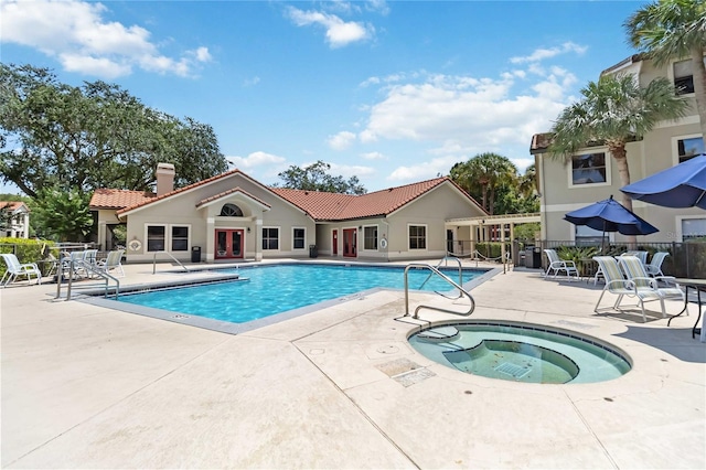 view of swimming pool featuring a community hot tub and a patio area