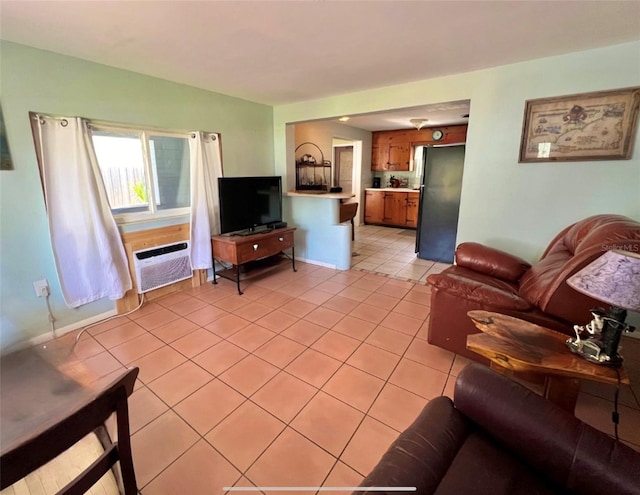 living area with light tile patterned floors and a wall mounted air conditioner