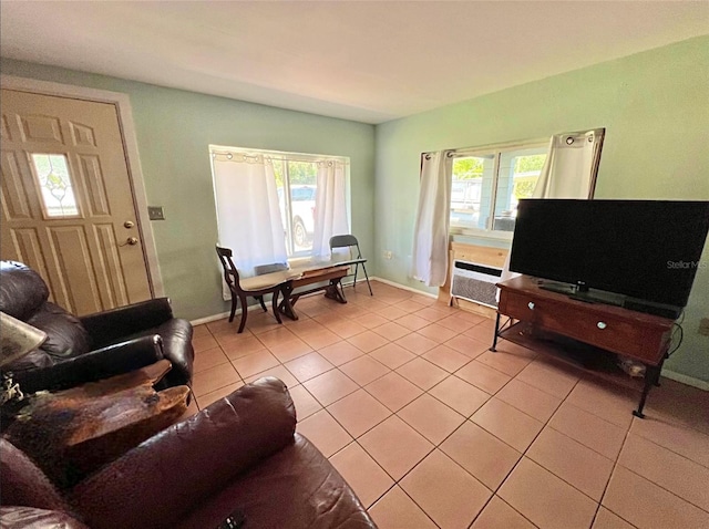 living area featuring light tile patterned floors, a healthy amount of sunlight, and baseboards