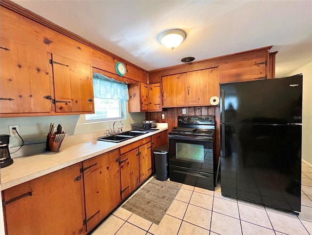 kitchen featuring light tile patterned floors, sink, and black appliances