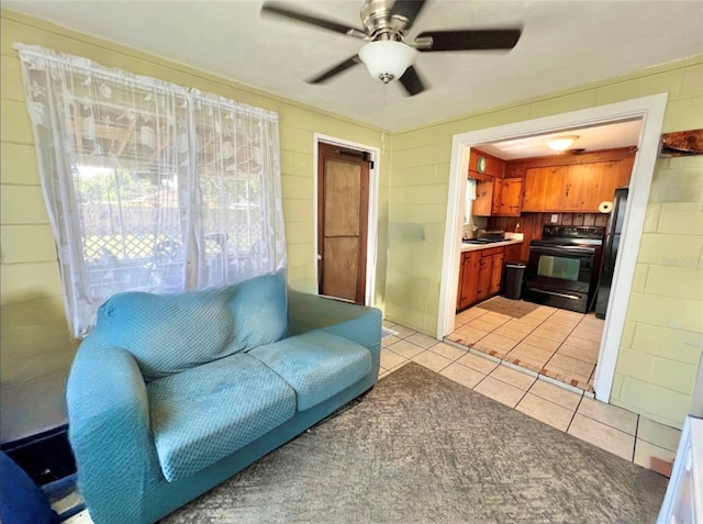 living area featuring light tile patterned floors and ceiling fan