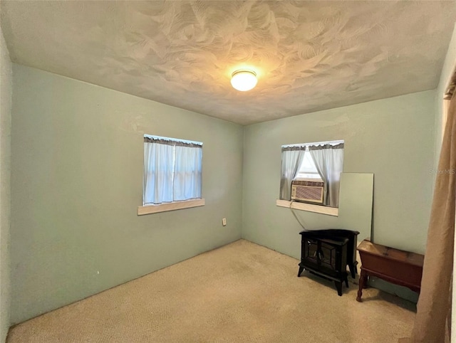 carpeted empty room featuring a wood stove and cooling unit