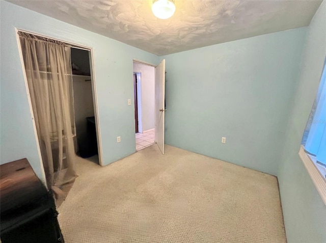 unfurnished bedroom with a closet and light colored carpet