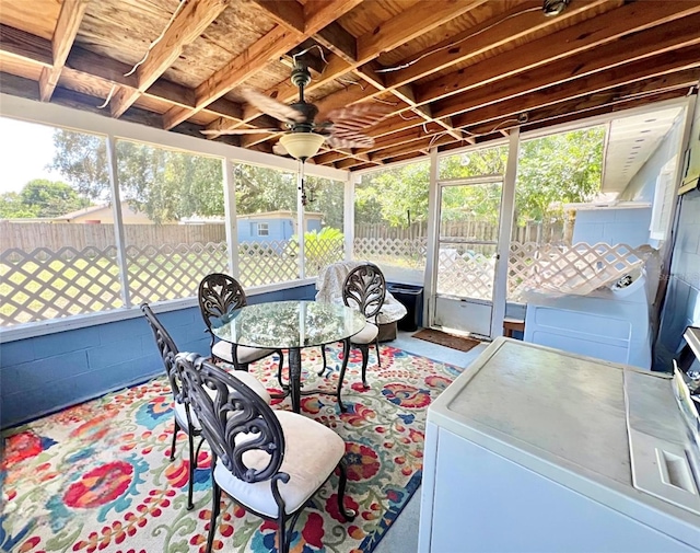 sunroom featuring a ceiling fan, independent washer and dryer, and a healthy amount of sunlight