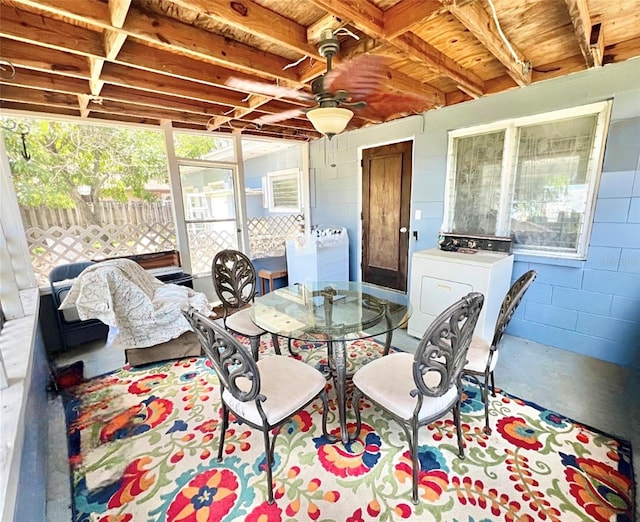 sunroom / solarium featuring ceiling fan, washer / dryer, and a healthy amount of sunlight