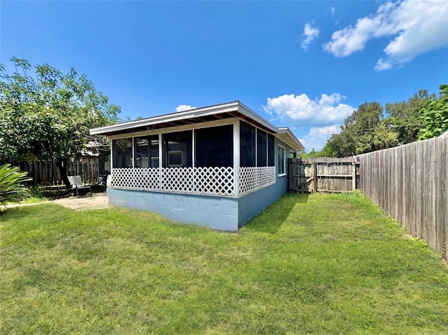 back of property with a lawn and a sunroom