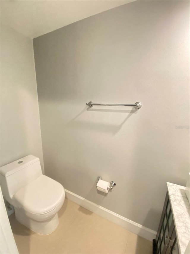 bathroom with toilet, tile patterned floors, and vanity