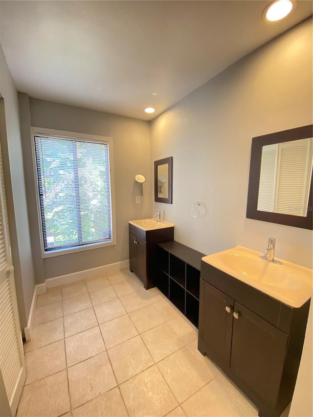 bathroom with dual bowl vanity and tile patterned flooring