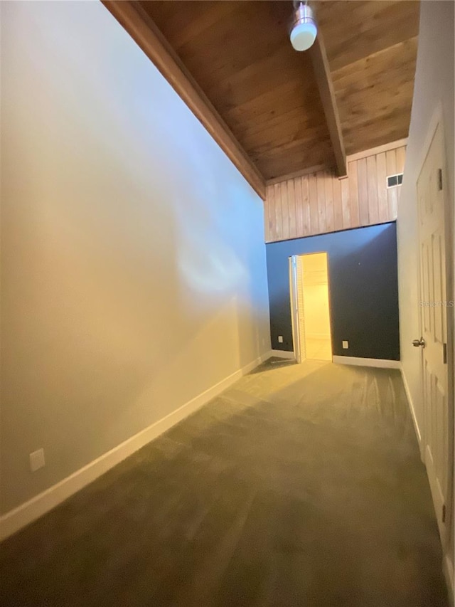 unfurnished room featuring carpet flooring, beamed ceiling, and wooden ceiling