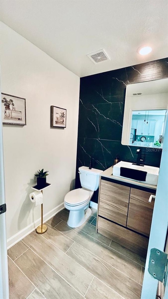 bathroom featuring tile walls, tile patterned flooring, vanity, and toilet