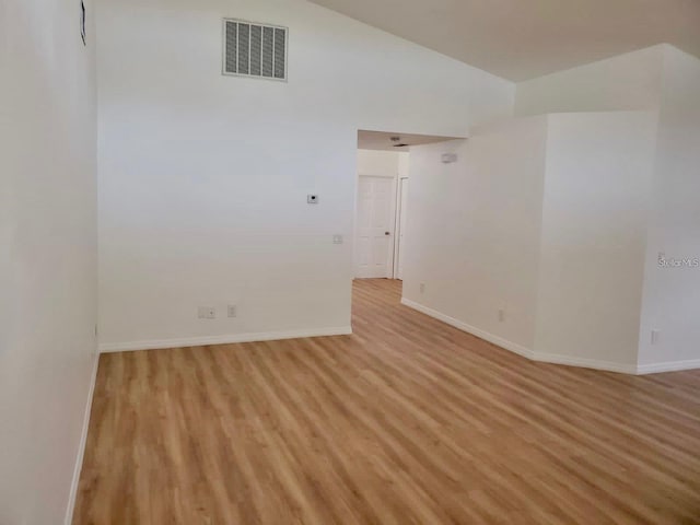 empty room with light wood-style floors, baseboards, and visible vents