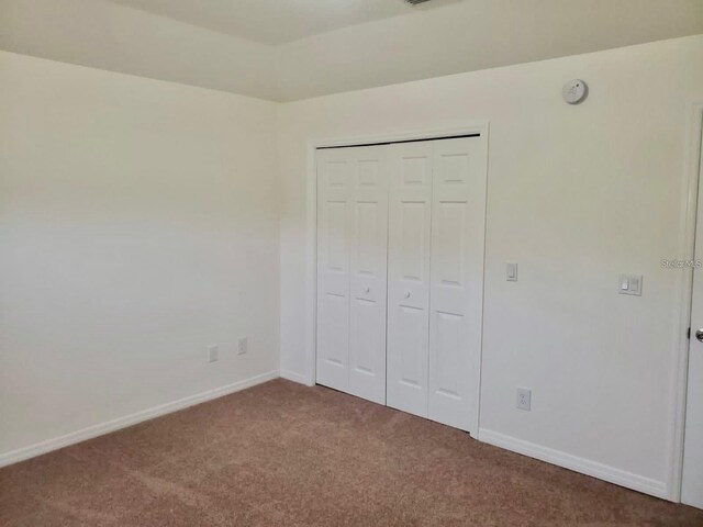 unfurnished bedroom featuring a closet and carpet floors