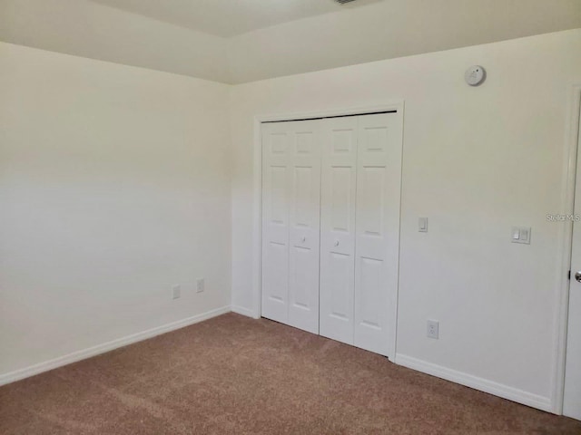 unfurnished bedroom featuring carpet floors, a closet, visible vents, and baseboards