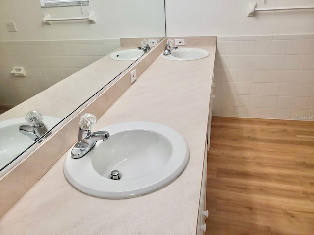 bathroom featuring a sink, tile walls, and double vanity