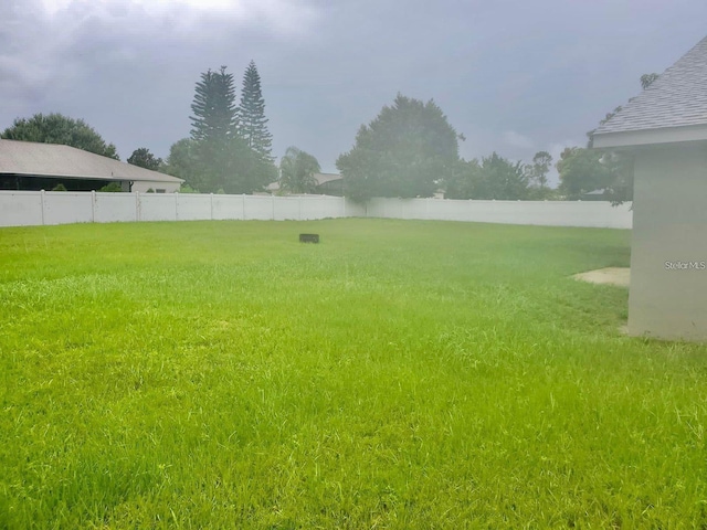 view of yard featuring a water view and fence