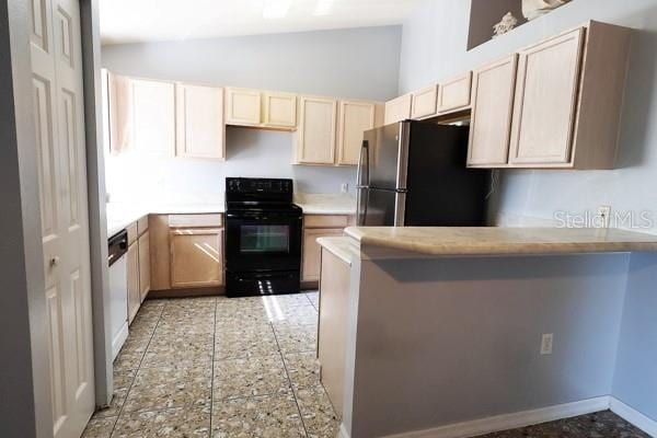 kitchen with light brown cabinets, stainless steel refrigerator, range, light tile patterned floors, and kitchen peninsula