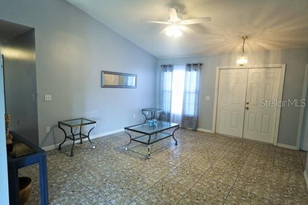 interior space with tile patterned flooring, ceiling fan, and lofted ceiling