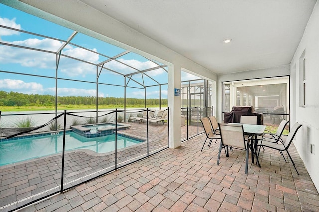 view of swimming pool with a patio area, glass enclosure, and an in ground hot tub