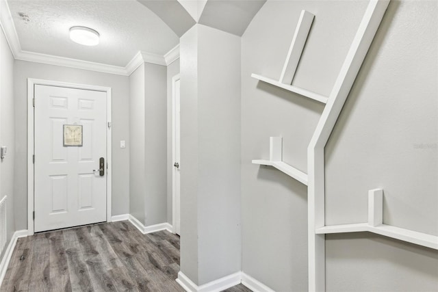 foyer with hardwood / wood-style flooring, crown molding, and a textured ceiling