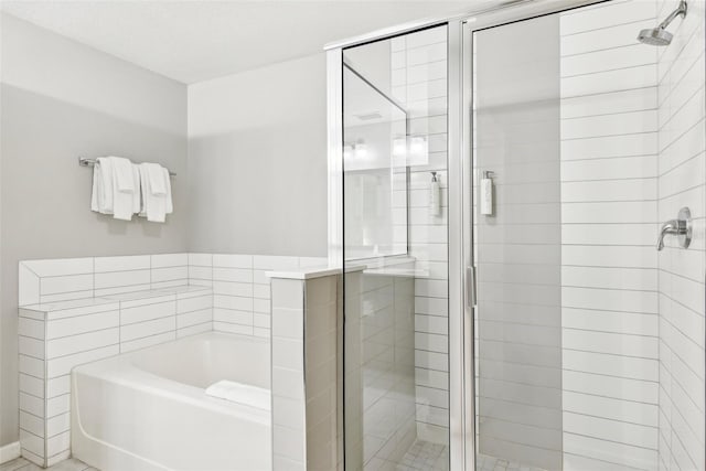 bathroom featuring shower with separate bathtub