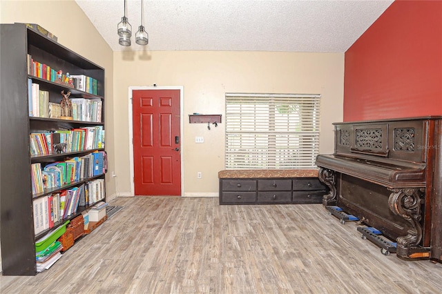 miscellaneous room with a textured ceiling and light wood-type flooring