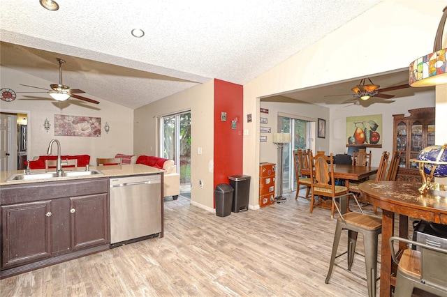 kitchen featuring dishwasher, sink, a textured ceiling, vaulted ceiling, and dark brown cabinets