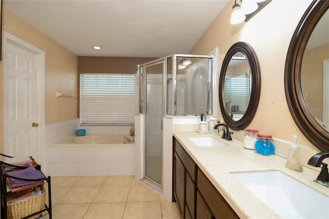 bathroom with tile patterned flooring, vanity, a textured ceiling, and shower with separate bathtub