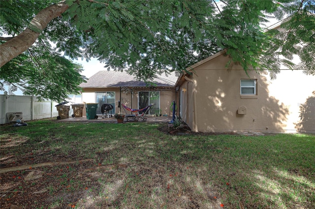 back of property with a patio area and a lawn