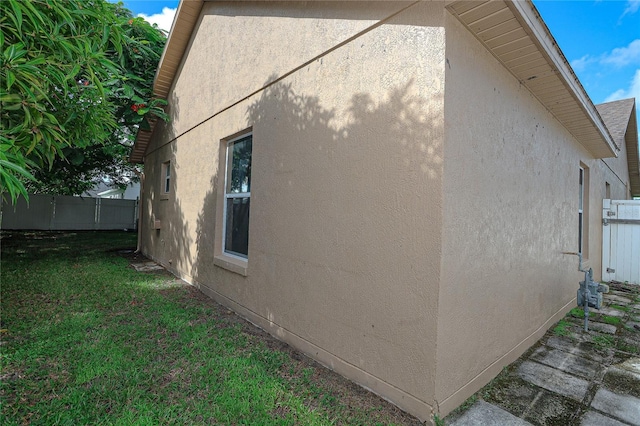 view of side of home with a yard