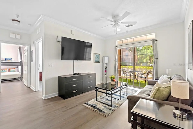 living room featuring ceiling fan, crown molding, and wood-type flooring