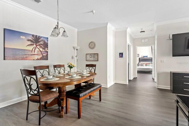 dining area with a textured ceiling, an inviting chandelier, crown molding, and dark wood-type flooring