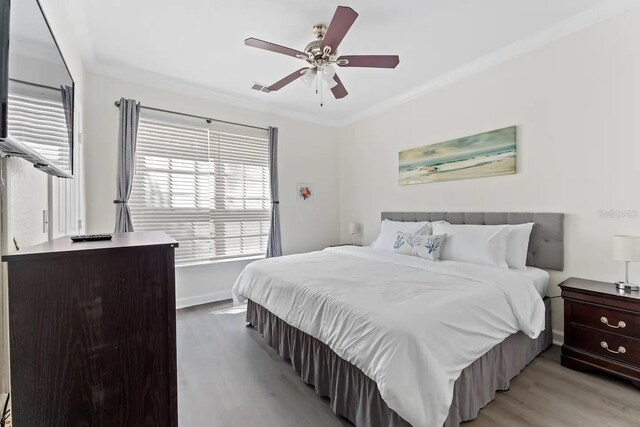 bedroom with ceiling fan, light hardwood / wood-style flooring, and ornamental molding