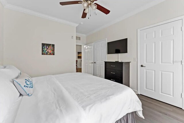 bedroom with ceiling fan, hardwood / wood-style floors, and ornamental molding