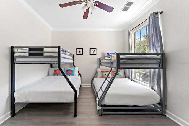 bedroom featuring ceiling fan, multiple windows, ornamental molding, and hardwood / wood-style flooring