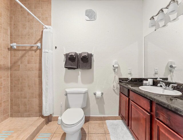 bathroom featuring tile patterned flooring, toilet, a shower with shower curtain, and vanity